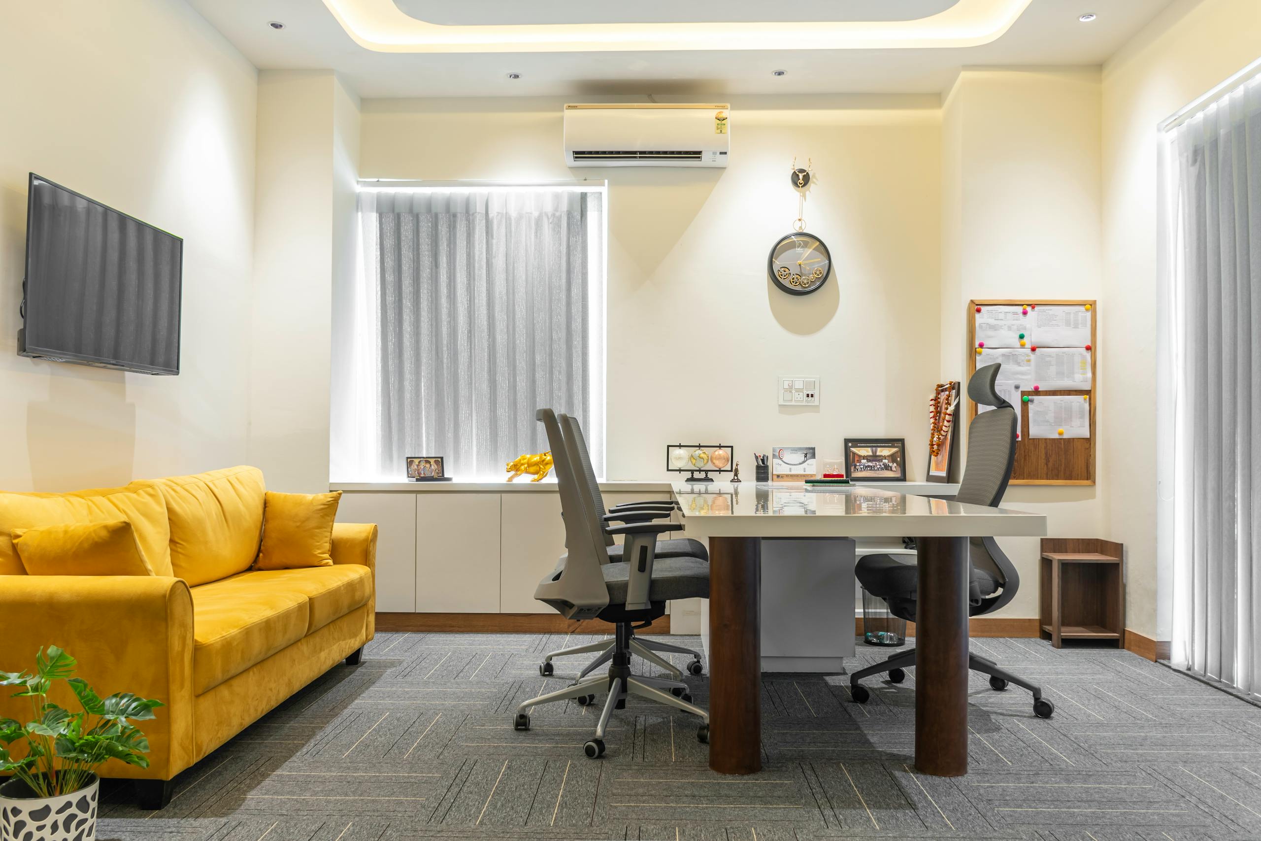 A bright and modern office space featuring a cozy yellow sofa and sleek furniture in Punjab, India.
