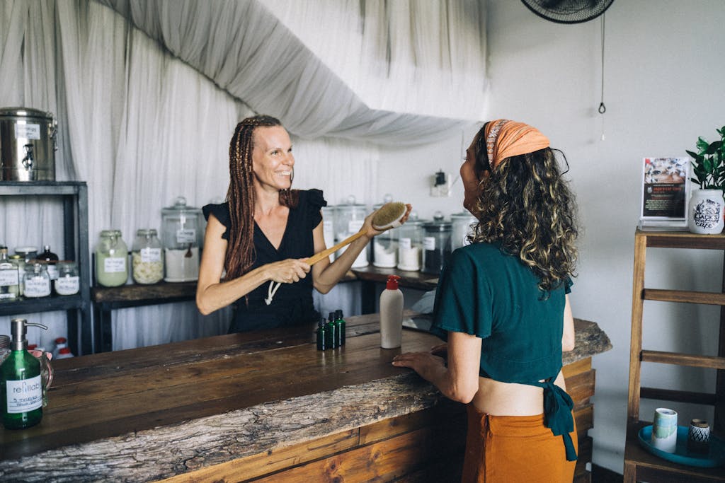 A customer buying natural skincare products from a cheerful shop owner.