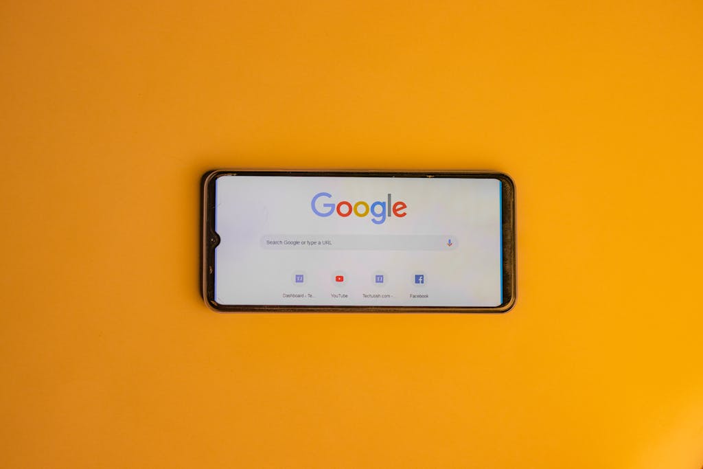 Blog 4 Smartphone displaying Google search page on a vibrant yellow background.
